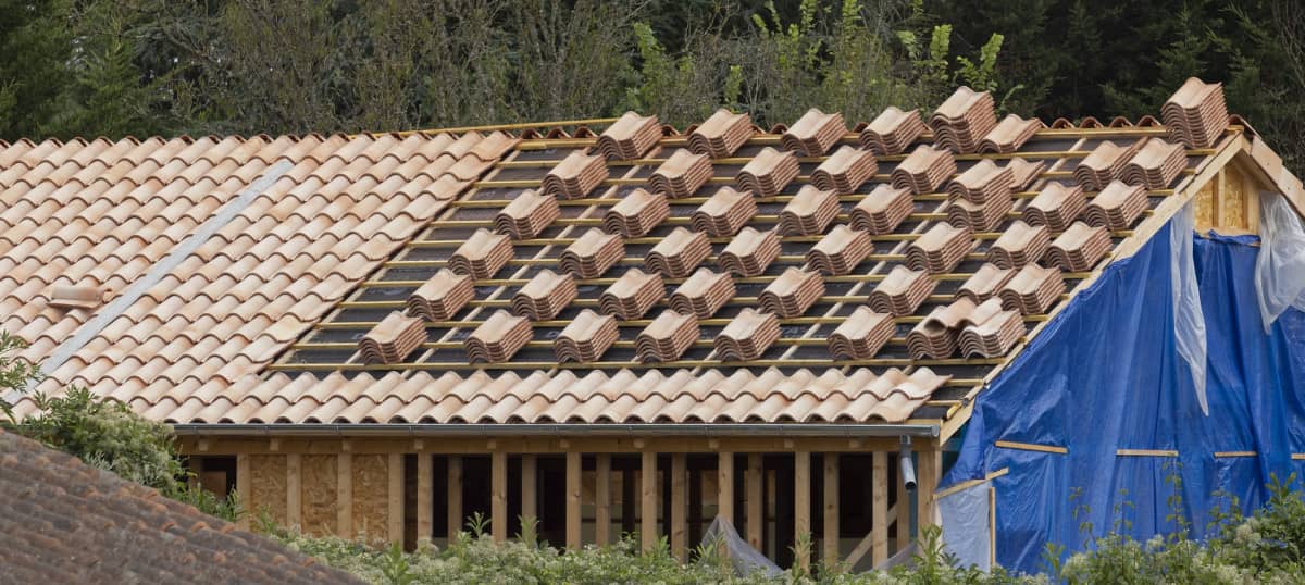Chantier de couverture en cours, tuiles en attente de pose sur les liteaux
