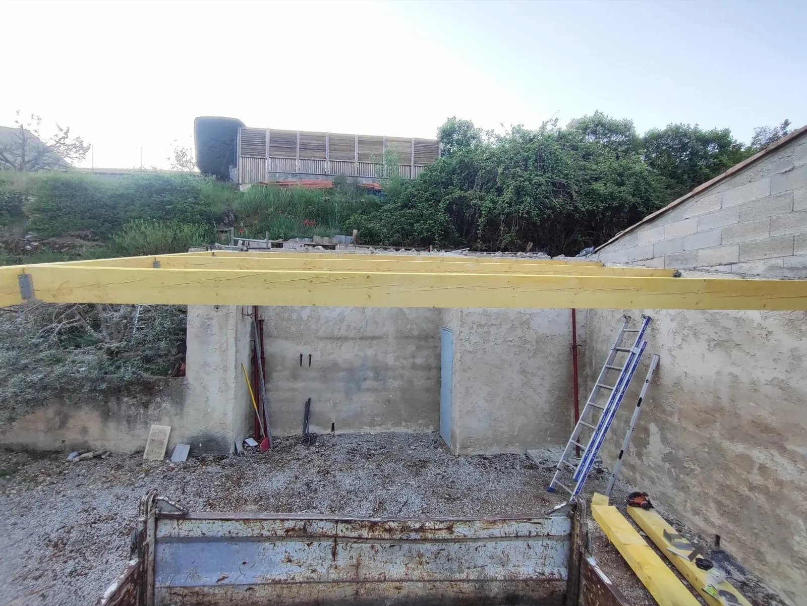 Ossature de charpente montée, remorque de chantier au premier plan