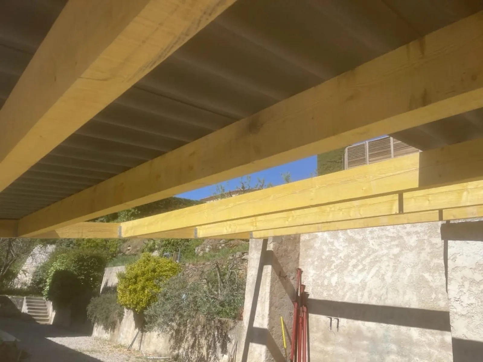 Poutres de charpente neuves, vues de dessous sous la couverture ondulée