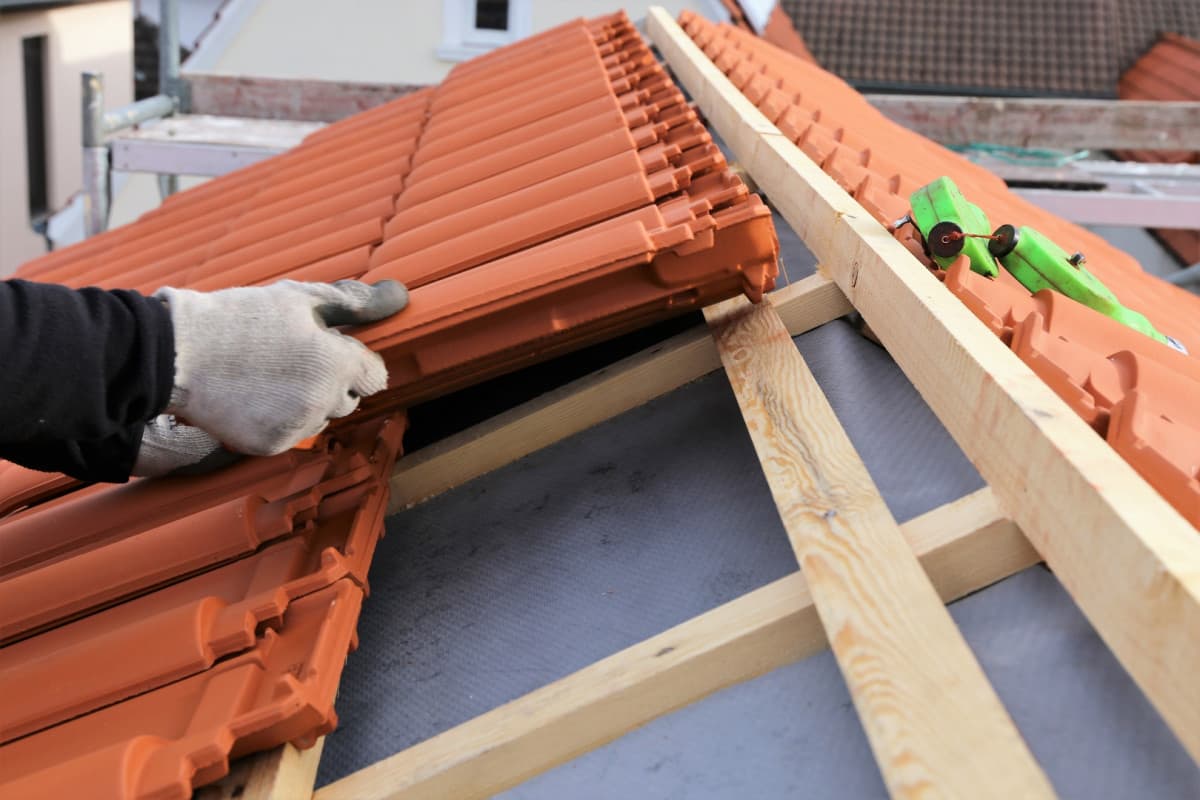 Travaux de couverture sur une toiture en tuiles